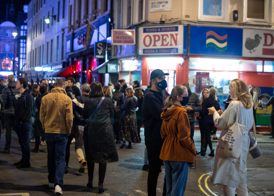 People leave bars and restaturants at closing time in Soho, London, the day after pubs and restaurants were subject to a 10pm curfew to combat the rise in coronavirus cases in England.