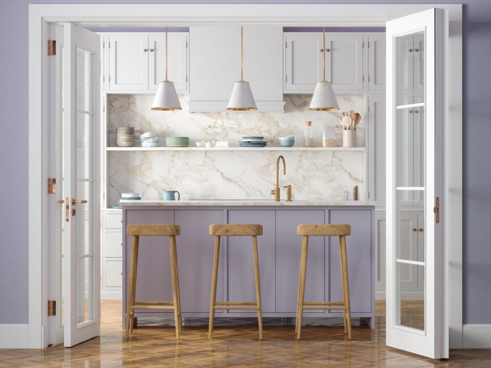 A lavender kitchen island with three barstools in a kitchen with a marble backsplash. The foreground depicts two French doors and a lavender wall