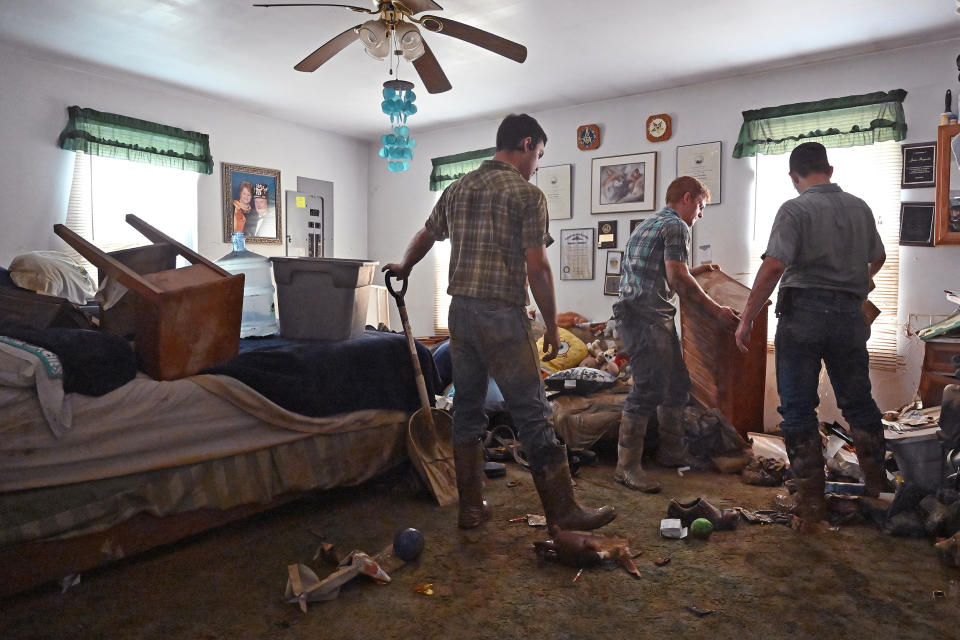 Volunteers from the local Mennonite community clean flood-damaged property Saturday at a house at Ogden Hollar in Hindman, Ky.  (Timothy D. Easley / AP)