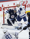 Winnipeg Jets goaltender Connor Hellebuyck (37) makes a save on Toronto Maple Leafs' John Tavares (91) as Nick Foligno (71) applies pressure during the second period of an NHL hockey game Friday, May 14, 2021, in Winnipeg, Manitoba. (John Woods/The Canadian Press via AP)