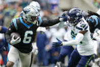 Carolina Panthers running back Miles Sanders pushes off Seattle Seahawks cornerback Devon Witherspoon during the first half of an NFL football game Sunday, Sept. 24, 2023, in Seattle. (AP Photo/Lindsey Wasson)