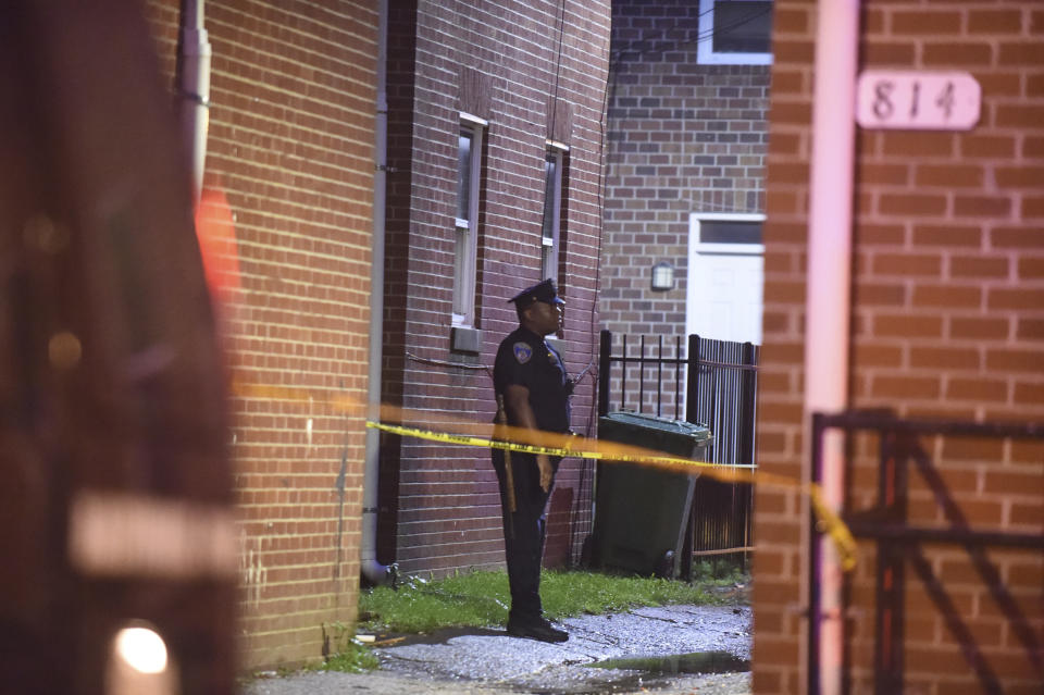 A Baltimore City police officer block stands near the scene of a shooting in Baltimore on Sunday, Sept. 23, 2018. The shootout between a man in a violence-prone Baltimore district and a police officer taking part in a crime suppression initiative has left the officer wounded and the suspect dead Sunday evening, Baltimore's interim police chief said. (Kenneth K. Lam/The Baltimore Sun via AP)