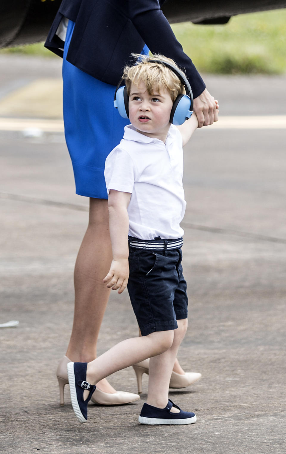 Looking adorably smart in belted navy shorts, a white T-shirt and his trademark navy blue T-bar sandals, the young prince donned ear protectors as he was shown the planes and given the opportunity to sit in one of the cockpits.