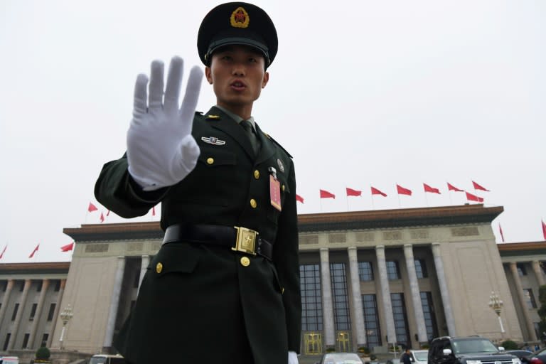 A Chinese soldier reacts to a photographer outside the Great Hall of the People during the 19th Communist Party Congress in Beijing