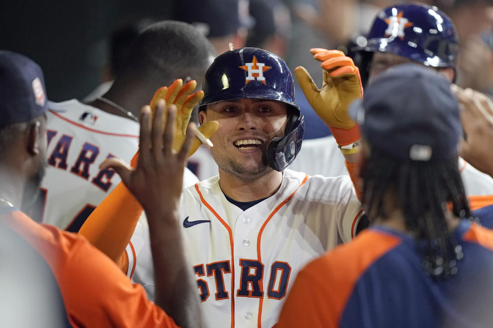 Houston Astros' Aledmys Diaz celebrates with teammates in the dugout after hitting a grand slam against the Texas Rangers during the fourth inning of a baseball game Tuesday, Aug. 9, 2022, in Houston. (AP Photo/David J. Phillip)