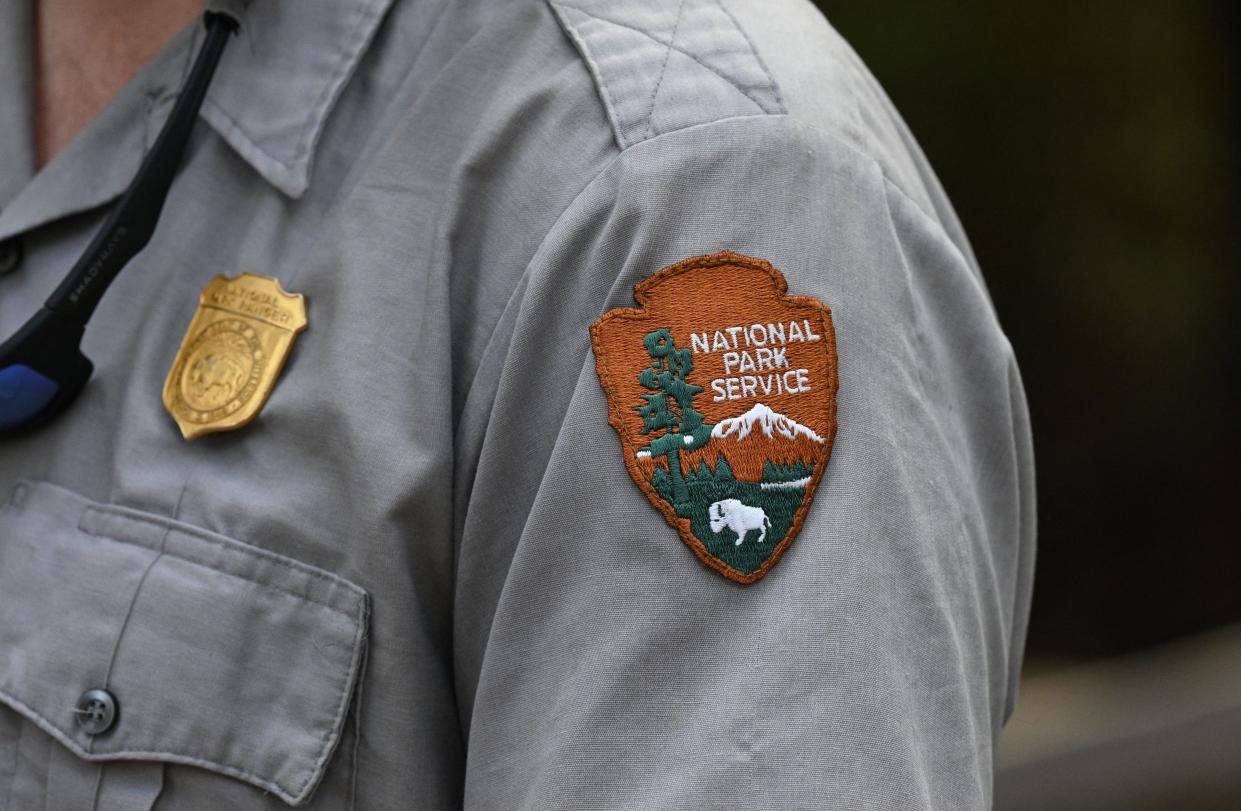 The National Park Service (NPS) badge is seen on a staff member's uniform during a media visit to the Giant Sequoia tree and mixed conifer forest of the Redwood Mountain Grove in Kings Canyon National Park in California's Sierra Nevada mountains, on August 24, 2023.