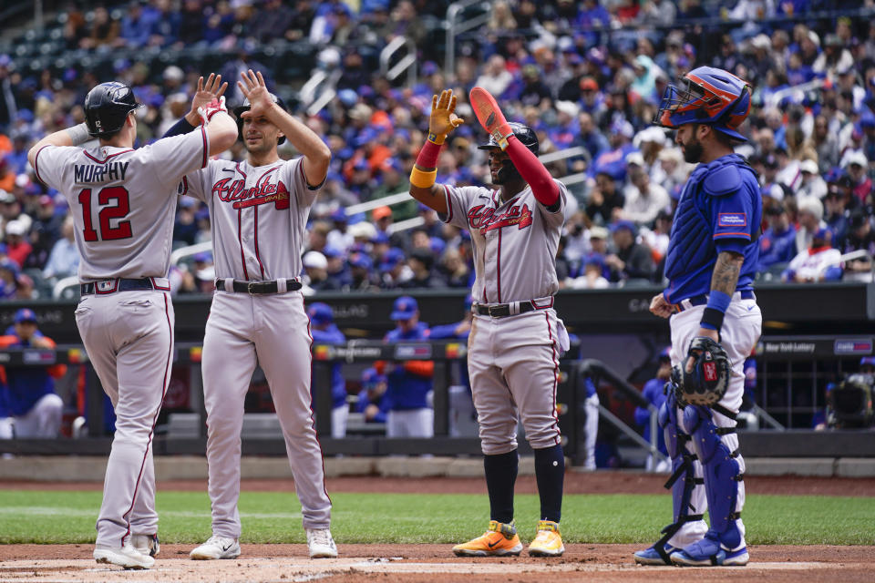 New York Mets catcher Tomas Nido, right, watches as Atlanta Braves' Sean Murphy (12) is greeted by teammates Matt Olson, second from left, and Ronald Acuna Jr. after hitting a three-run home run during the first inning of the first game of a baseball doubleheader at Citi Field, Monday, May 1, 2023, in New York. (AP Photo/Seth Wenig)