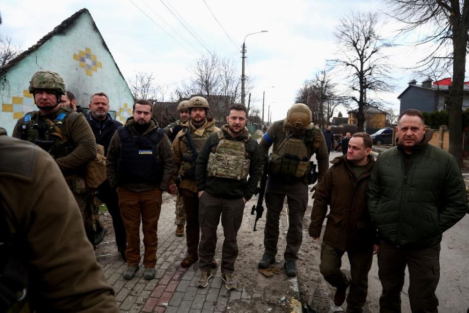 Zelensky looks on as he stands with a number of Ukrainian servicemen (REUTERS)