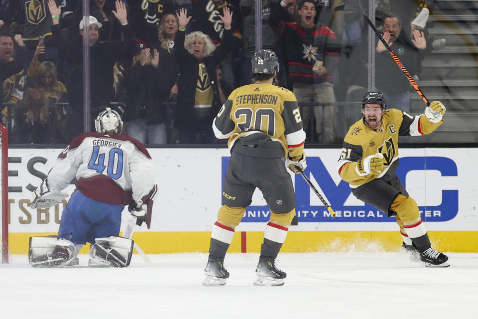 Colorado Avalanche goaltender Alexandar Georgiev (40) and Vegas Golden Knights center Chandler Stephenson (20) look on as Vegas Golden Knights right wing Mark Stone, right, celebrates after scoring a goal during the first period of an NHL hockey game Saturday, Nov. 4, 2023, in Las Vegas. (AP Photo/Ian Maule)