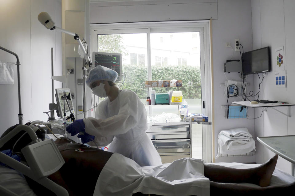 Nurse Stephanie Dias tends to a patient affected by COVID-19 virus in the ICU unit at the Ambroise Pare clinic in Neuilly-sur-Seine, near Paris, Friday, March 19, 2021. French Prime Minister Jean Castex announced new coronavirus restrictions as the number of COVID-19 patients in intensive care units spikes. (AP Photo/Thibault Camus)