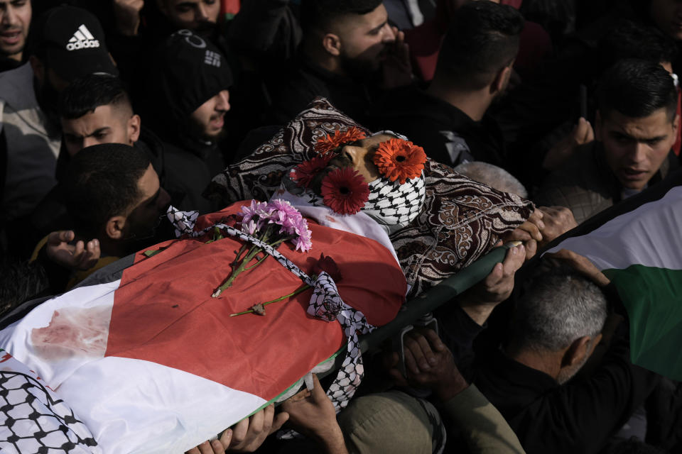 Palestinian mourners carry the body of Ahmad Kahla, 45, during his funeral in the West Bank village of Rammun, Sunday, Jan. 15, 2023. The Palestinian Health Ministry says Israeli troops have shot and killed the Palestinian man in the occupied West Bank. The Israeli military said troops opened fire when a passenger in a suspicious vehicle tried to grab a soldier's weapon. (AP Photo/Majdi Mohammed)