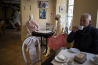 Mannequins are placed to provide social distancing at a restaurant in Vilnius, Lithuania, Thursday, May 21, 2020. In Vilnius, cafes and restaurants have been allowed to accept customers indoor, however, strict social distancing rules must be kept: the indoor establishments need to ensure a space of five square metres per person. The Lithuanian government extended the nationwide coronavirus quarantine until May 31. (AP Photo/Mindaugas Kulbis)