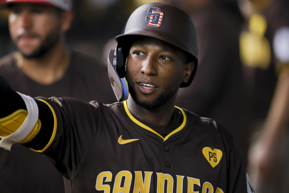 San Diego Padres' Jurickson Profar celebrates with teammates in the dugout after successfully completing a sacrifice bunt during the eighth inning of a baseball game against the Texas Rangers, Thursday, July 4, 2024, in Arlington, Texas. (AP Photo/Gareth Patterson)