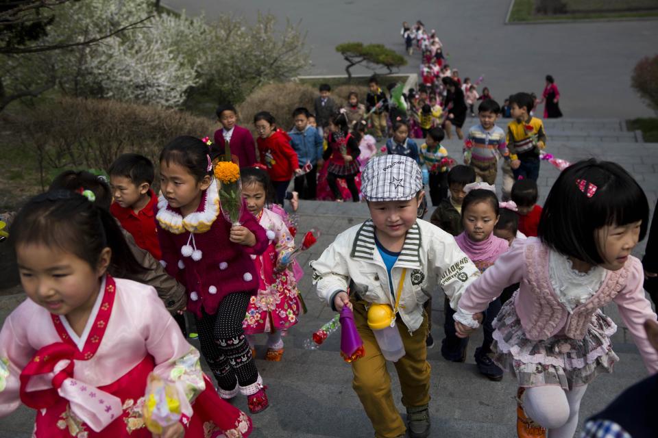 North Korean children climb steps near Mansu Hill in Pyongyang on their way to lay flowers at the feet of bronze statues of the late North Korean leaders Kim Il Sung and Kim Jong Il on Saturday, April 12, 2014. (AP Photo/David Guttenfelder)