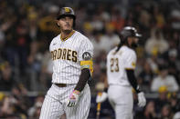 San Diego Padres' Manny Machado, left, passes teammate Fernando Tatis Jr. after striking out during the fourth inning of a baseball game against the San Francisco Giants, Thursday, Aug. 31, 2023, in San Diego. (AP Photo/Gregory Bull)