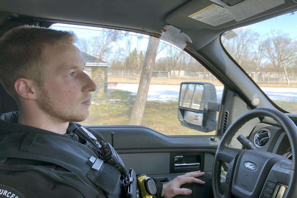 In this March 5, 2020, photo, Wisconsin Department of Natural Resources Warden Austin Schumacher recalls how he rescued a 13-year-old boy who vanished in a marsh in November, as he sits in his vehicle in the Edgerton, Wis., park where the search began. This month, Schumacher received the DNR’s Lifesaving Award. His training officer, Warden Tim Werner, said he wasn't surprised at Schumacher's valor. Nor was he surprised that Schumacher’s woodland expertise had had been put to use. (AP Photo/Todd Richmond)