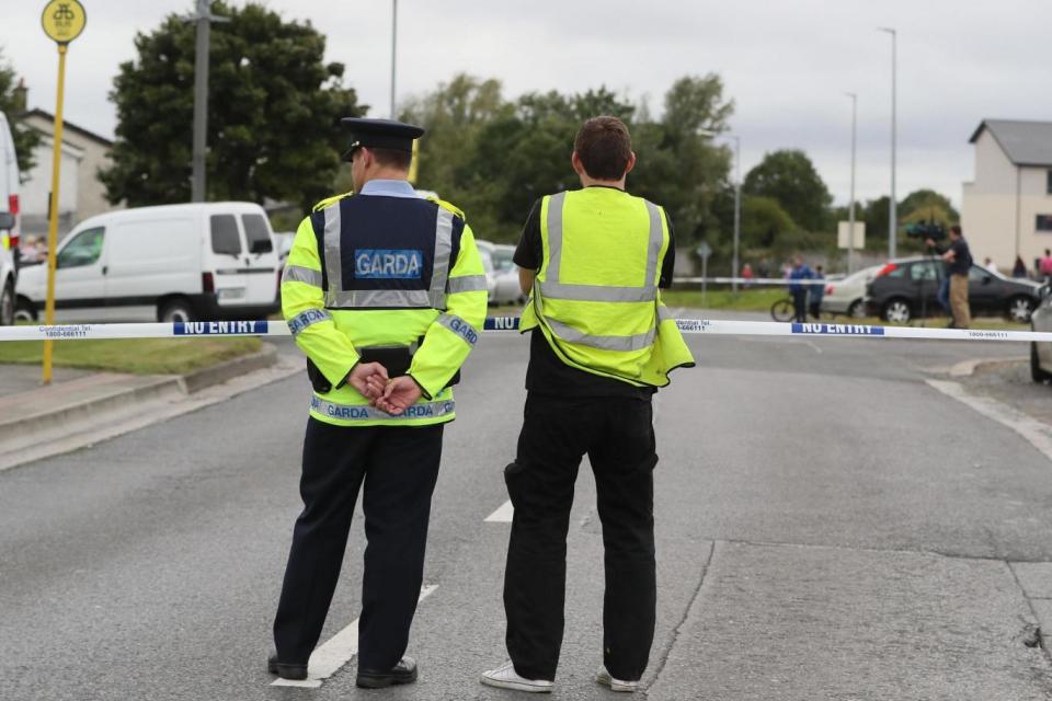 Police guard a cordon near to the scene where a man and woman were shot dead in Dublin (PA)