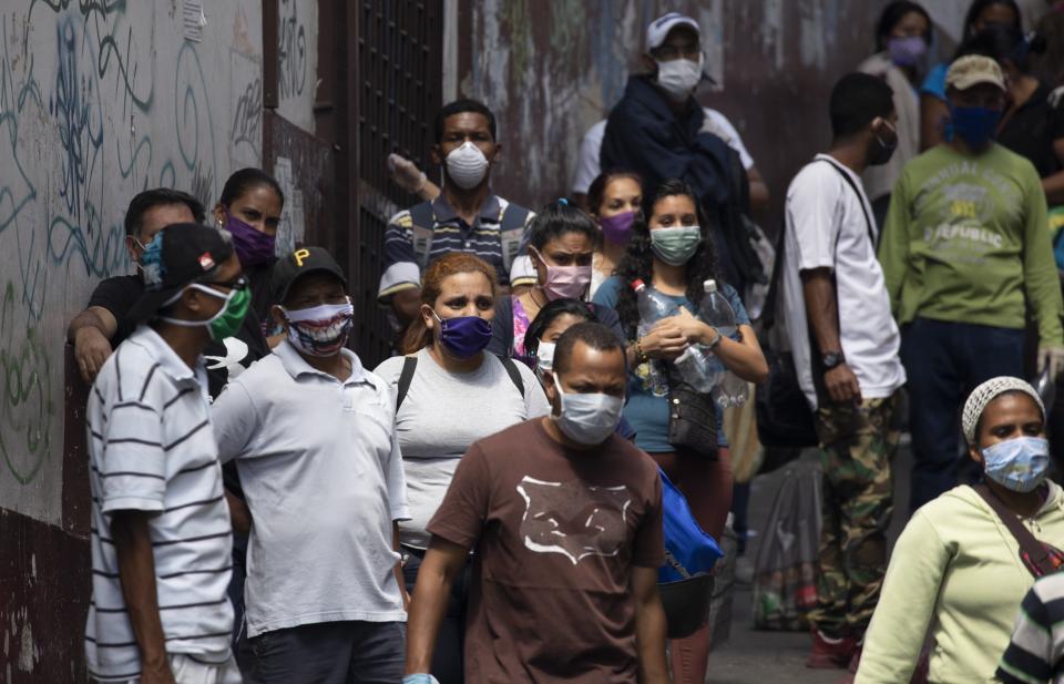 People line up to buy food and disinfectant, some wearing face masks as a preventive measure against the spread of the new coronavirus in Caracas, Venezuela, on March 26, 2020.&nbsp; (Photo: AP Photo/Ariana Cubillos)