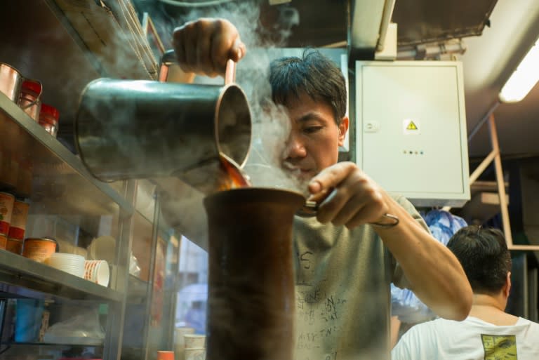 A tea master makes a milk tea -- or "lai cha" -- a tangy brew made from blends of black tea strained repeatedly through a sock-like cloth, at a tea shop in Hong Kong's Central district on August 10, 2016