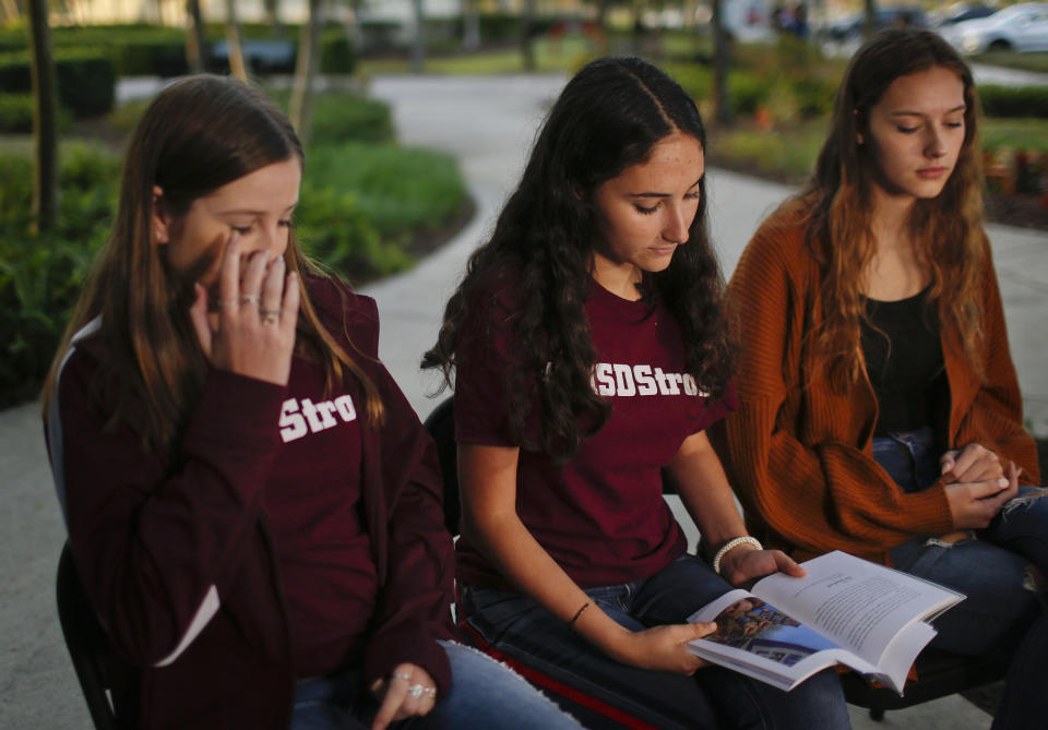 In this Wednesday, Jan. 16, 2019, photo, Brianna Fisher, 16, left, Leni Steinhardt, 16, center, and Brianna Jesionowski sit during an interview with The Associated Press about a new book called "Parkland Speaks: Survivors from Marjory Stoneman Douglas Share Their Stories," in Parkland, Fla. Students and teachers from the Florida school where 17 died in February’s high school massacre wrote the raw, poignant book about living through the tragedy. (AP Photo/Brynn Anderson)