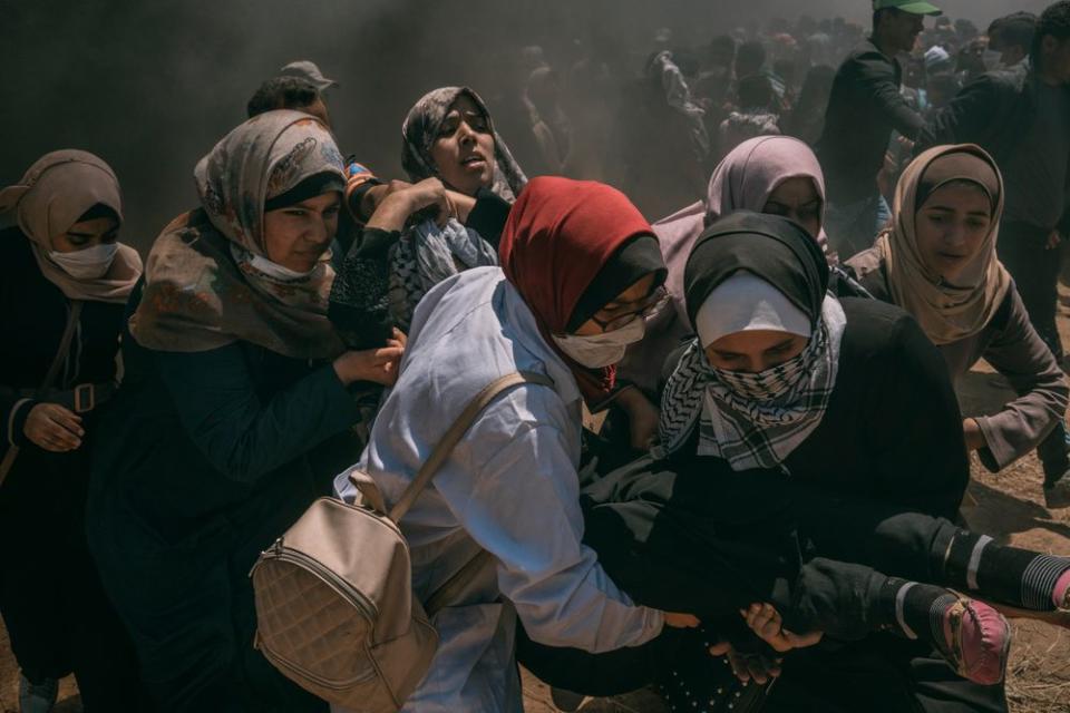 A wounded woman is evacuated by other women after she was injured in the head during the protest along the Gaza-Israel border.