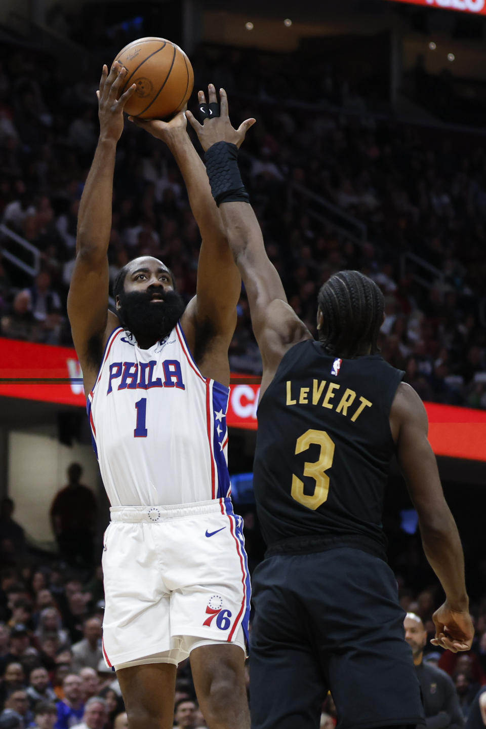 Philadelphia 76ers guard James Harden (1) shoots against Cleveland Cavaliers guard Caris LeVert (3) during the second half of an NBA basketball game, Wednesday, March 15, 2023, in Cleveland. (AP Photo/Ron Schwane)