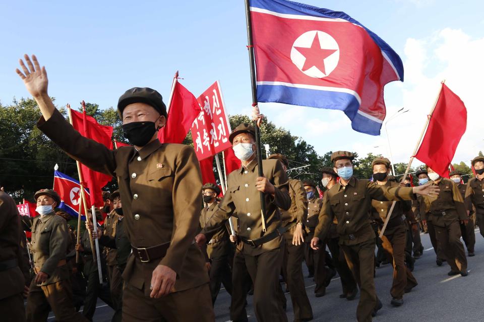 Political party members in support of the recovery efforts from typhoon damage parade at the plaza of the Kumsusan Palace of the Sun in Pyongyang, North Korea, Tuesday, Sept. 8, 2020. A powerful typhoon damaged buildings and flooded roads in North Korea on Monday, the fourth spell of strong wind and rain to hit the country in just over a month. (AP Photo/Jon Chol Jin)