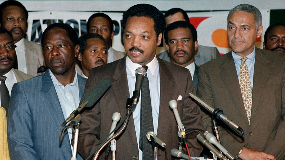 Rev. Jesse Jackson, center, is joined by baseball great Hank Aaron, left, at a meeting of Operation PUSH at the Sheraton in Rosemont, Illinois, Monday, June 29, 1987. - Mark Elias/AP