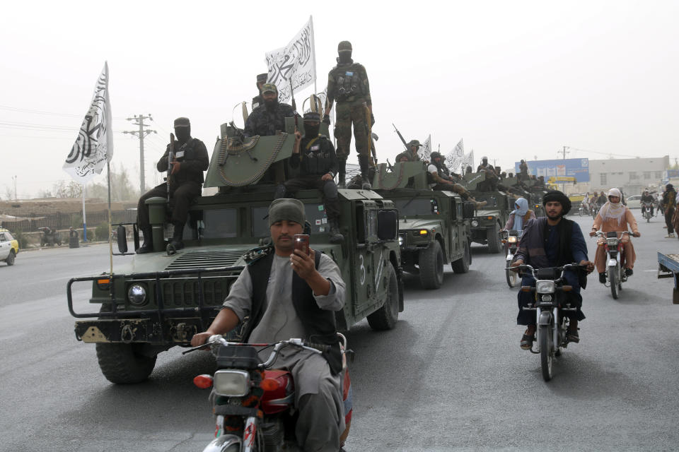 Taliban fighters patrol on the road during a celebration marking the second anniversary of the withdrawal of U.S.-led troops from Afghanistan, in Kandahar, south of Kabul, Afghanistan, Tuesday, Aug. 15, 2023. (AP Photo/Abdul Khaliq)