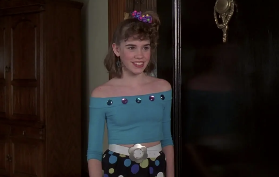 Christa wearing an off the shoulder '80s outfit with hair in a side pony