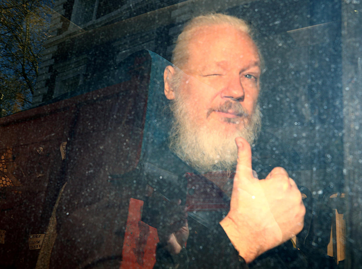 WikiLeaks founder Julian Assange, bearded and giving a thumbs-up sign, after he was arrested in London in 2019. 