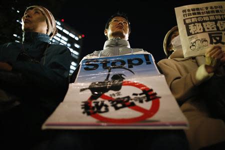 A protester holds a placard reading "Stop Secrecy Act" during a rally against the government's planned secrecy law, in Tokyo November 21, 2013. REUTERS/Issei Kato