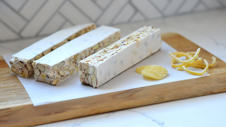 sliced nougat on cutting board with candied lemon and ginger