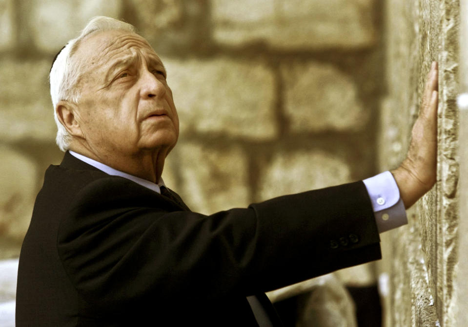 FILE - In this Wednesday Feb. 7, 2001 file photo, Ariel Sharon, then Israel's Prime Minister-elect, looks up as he touches Judaism holiest site, the Western Wall, in Jerusalem. The son of former Israeli Prime Minister Ariel Sharon says his father has died on Saturday, Jan. 11, 2014. The 85-year-old Sharon had been in a coma since a debilitating stroke eight years ago. His son Gilad Sharon said: "He has gone. He went when he decided to go." (AP Photo/David Guttenfelder, File)