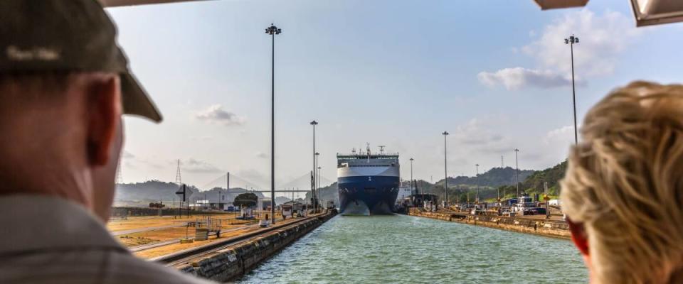 Panama Canal, Panama - Mar 11th 2018 - Tourists looking to a huge ship entering one of the canal locks in a blue sky day in Panama