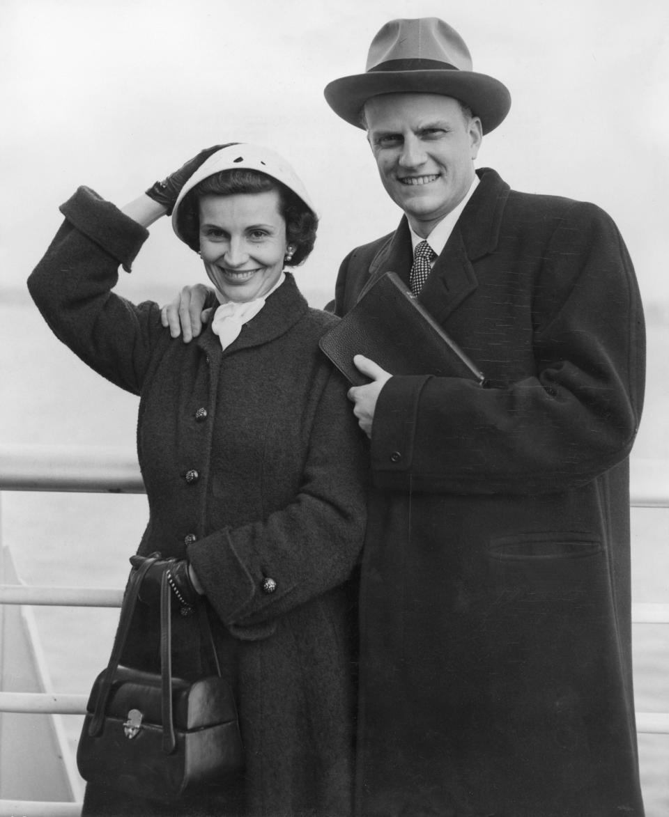 SOUTHAMPTON, UNITED KINGDOM:  Billy Graham, the American evangelist, and his wife Ruth, pose aboard the liner 'United States' 23 February 1954 before their arrival from New York to Southampton. Graham, (son of a dairy farmer, born in 1918 in Charlotte, NC), attended Florida Bible Institute and was ordained a Southern Baptist minister in 1939 and quickly gained a reputation as a preacher. During the 1950s he conducted a series of highly organized revivalist campaigns in the USA and UK, and later in South America, the USSR and Western Europe. (Photo credit should read AFP/Getty Images)