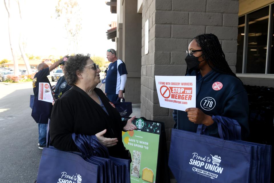 United Food and Commercial Workers Local 770 staffers Kenya McElrath, right, and Jackie Gitmed chat as they hand out information about a proposed grocery chain merger in front of a Ralphs in Thousand Oaks on Thursday, April 6, 2023. The gathering at the Moorpark Road store was one among ongoing rallies by the union opposing the merger of Kroger and Albertsons.