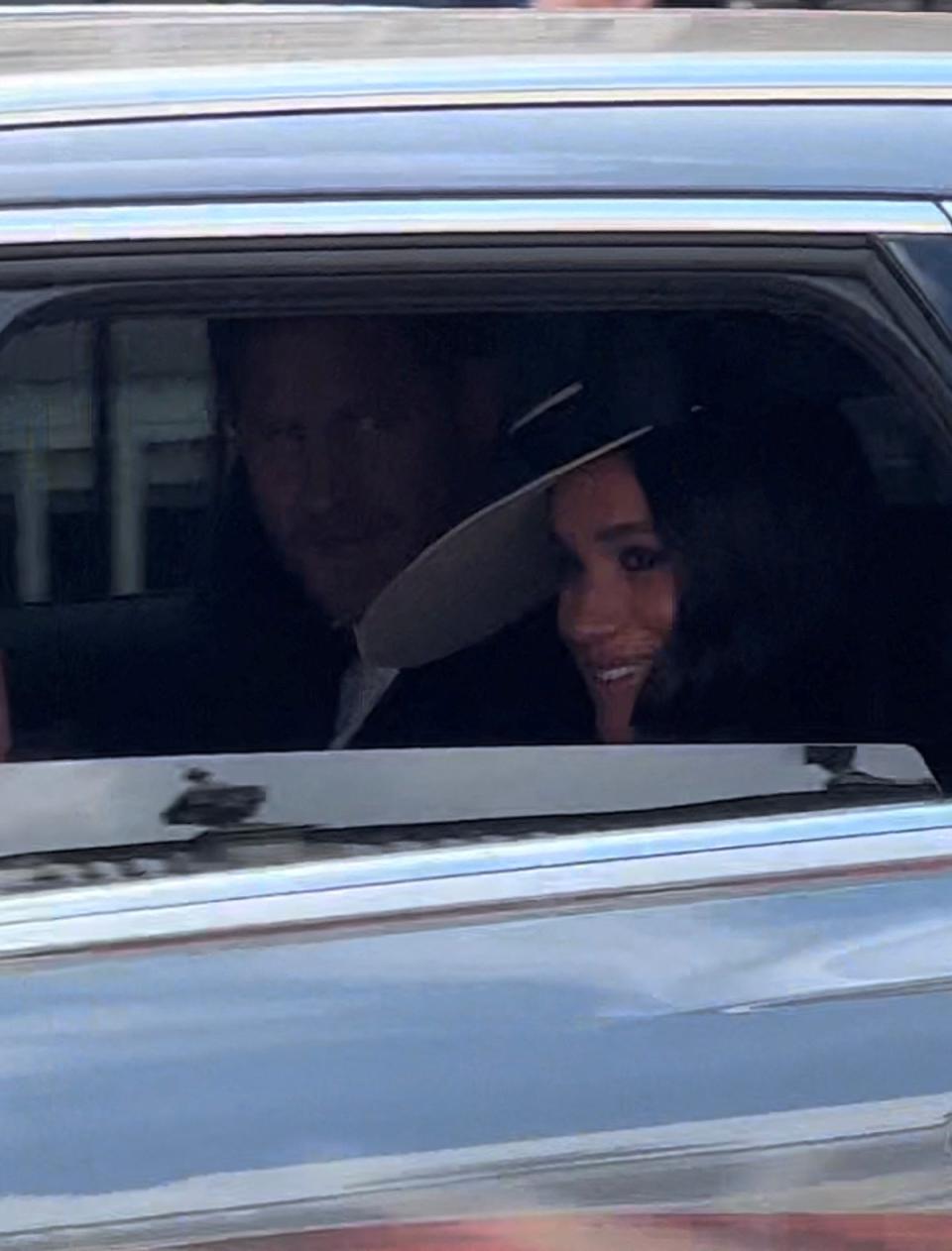 Prince Harry and Meghan Markle smile at fans as they drive through London (Emily Sevenoaks via REUTERS)