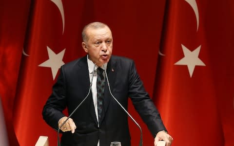 Recep Tayyip Erdogan said he would "open the door" to Europe for millions of Syrian refugees if the EU called the Turkish operation an "invasion" - Credit: REX