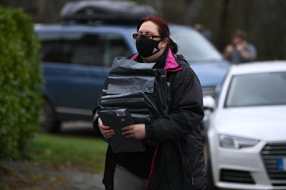 WOKING, ENGLAND - FEBRUARY 02: Volunteers deliver testing kits to residents as local authorities deploy covid-19 testing in an effort to track down a South African coronavirus variant found in the area on February 2, 2021 in Woking, United Kingdom. Health authorities have found more than 100 cases of a coronavirus variant first identified in South Africa,  prompting a scramble to deploy new testing initiatives across eight areas in England. It is thought the variant is more contagious, but not more deadly, than the variant that has predominated in England throughout the covid-19 pandemic. (Photo by Leon Neal/Getty Images)