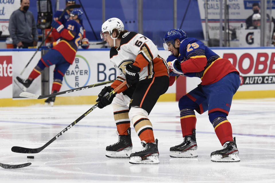 St. Louis Blues' Jordan Kyrou (25) pressures Anaheim Ducks' Rickard Rakell (67) during the third period of an NHL hockey game on Monday, May 3, 2021, in St. Louis. (AP Photo/Joe Puetz)