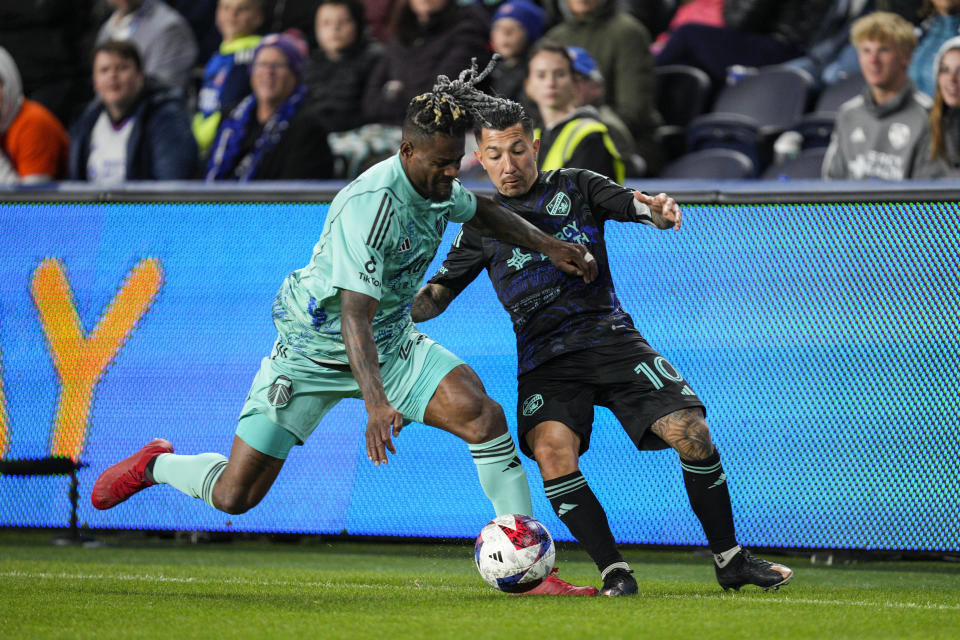 Portland Timbers forward Dairon Asprilla, left, battles with FC Cincinnati midfielder Luciano Acosta (10) during the second half of an MLS soccer match Saturday, April 22, 2023, in Cincinnati. (AP Photo/Jeff Dean)