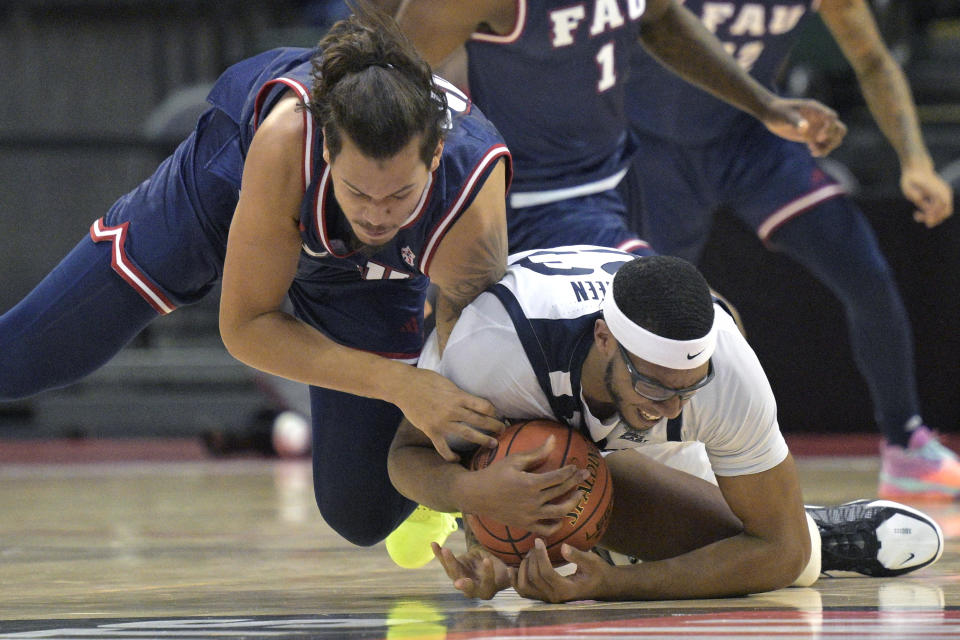 Florida Atlantic forward Tre Carroll, left, and Butler center Andre Screen (23) battle for a loose ball during the first half of an NCAA college basketball game, Thursday, Nov. 23, 2023, in Kissimmee, Fla. (AP Photo/Phelan M. Ebenhack)