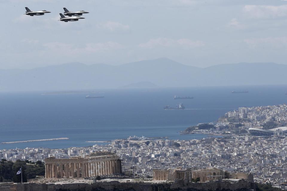 Greek Air Force F16's fly over the Parthenon, on the ancient Acropolis hill during a military parade in Athens, Tuesday, March 25, 2014, to commemorate Greek Independence Day. The national holiday on March 25 marks the start of Greece's 1821 war of independence against the 400-year Ottoman rule. (AP Photo/ Petros Giannakouris)