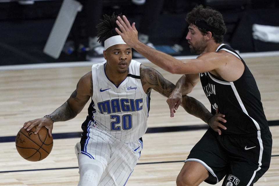 Orlando Magic's Markelle Fultz (20) heads to the basket as Brooklyn Nets' Joe Harris, right, defends during the first half of an NBA basketball game Friday, July 31, 2020, in Lake Buena Vista, Fla. (AP Photo/Ashley Landis, Pool)