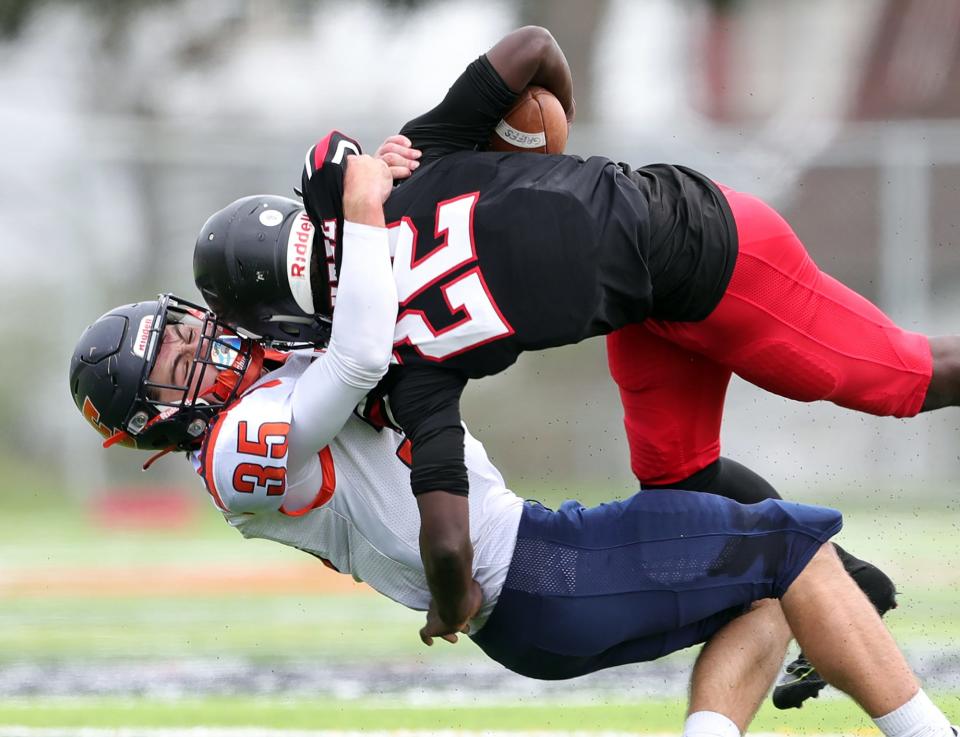 Ellet's Cameron Hinkle, bottom, brings down Buchtel running back Justin Hill during the first half of a high school football game, Saturday, Sept. 24, 2022, in Akron, Ohio.