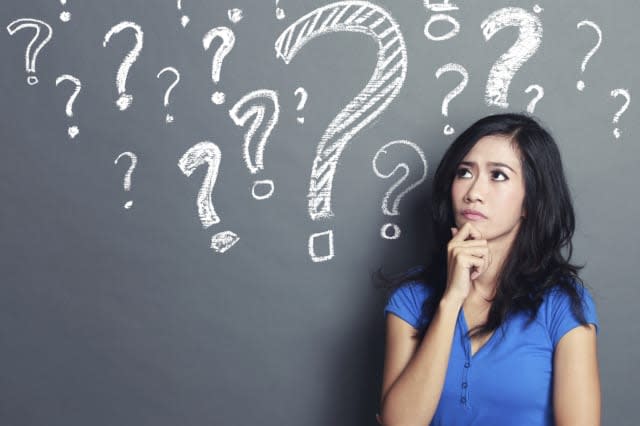 young woman with question mark on a gray background