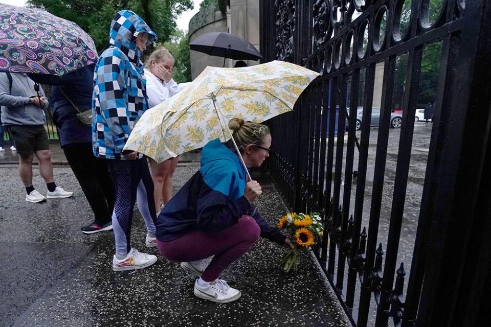 Una persona deposita flores a las afueras del palacio de Holyroodhouse en Edinburgo.