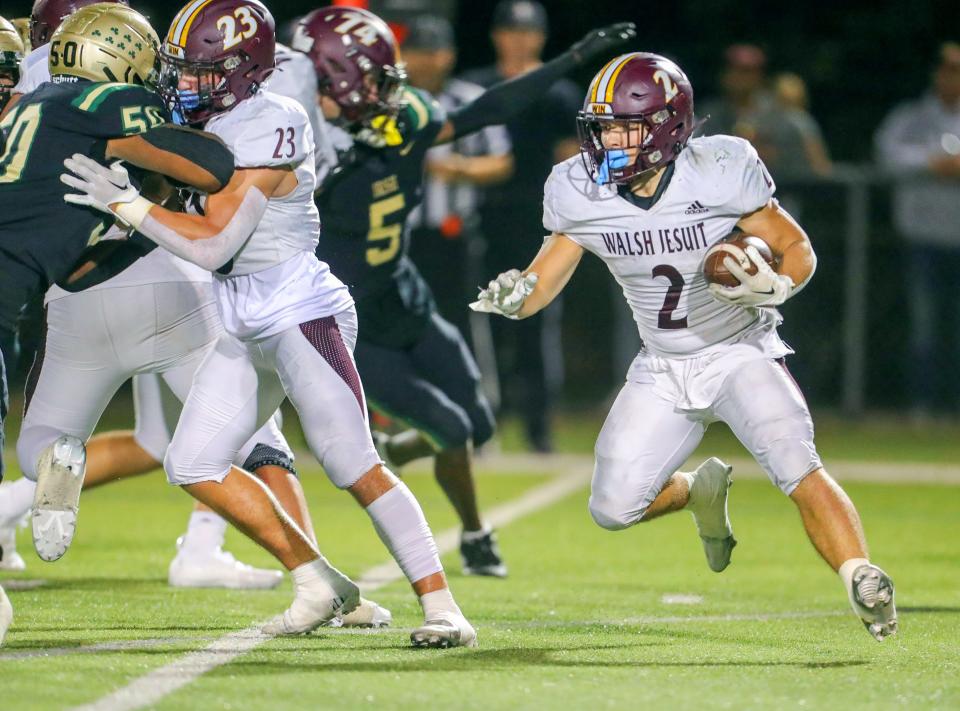 Walsh Jesuit running back Lucas Weaver runs around a block by Cade Romanini during the third quarter against St. Vincent-St. Mary on Sept. 22.