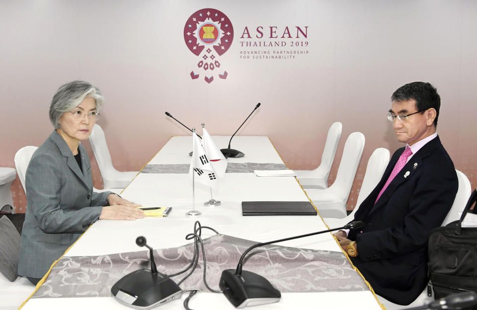 Japanese Foreign Minister Taro Kono, right, and his South Korean counterpart Kang Kyung-wha sit at a table for a bilateral meeting on the sidelines of the ASEAN Foreign Ministers Meetings in Bangkok, Thailand, Thursday, Aug. 1, 2019. (Naohiko Hatta/Kyodo News via AP)